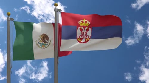Mexico and Serbia National Flags Waving Against Blue Sky