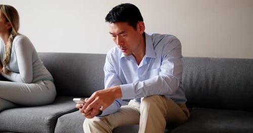 Couple on Couch, Man on Phone, Conflict