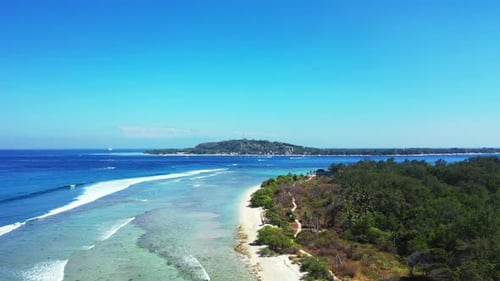 Aerial drone view panorama of tranquil shore beach break by blue lagoon and white sandy background o