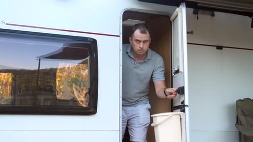 Man Opens RV Door on a Camping Trip
