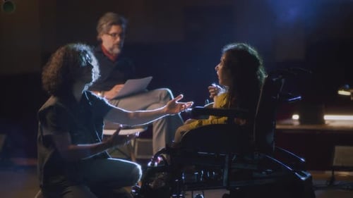 Director Reviews Scene with Actors On Dark Stage