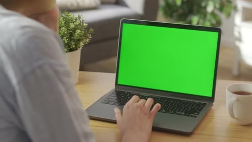 Closeup On the Hands of the Female Specialist Works on a Laptop Computer with Mockup Green Screen