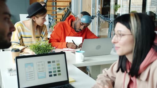 Smartphone App Designers Talking Working in Pairs in Modern Office