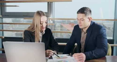Man and a Woman Discussing Work in the Brightly Lit Modern Office. Concerned Male and Female Working
