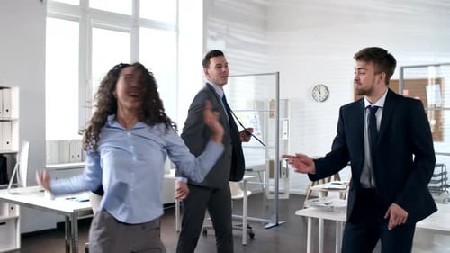 Excited Colleagues Dancing Together in the Office