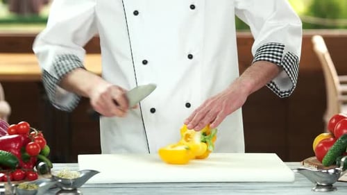 Chef Cuts Yellow Pepper on Cutting Board