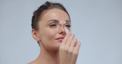 Woman Using Facial Massager on Forehead Close Up