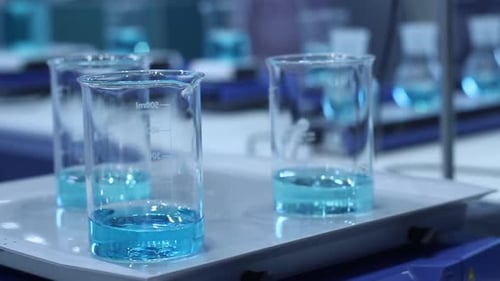 Science Beakers With Blue Liquid in Laboratory