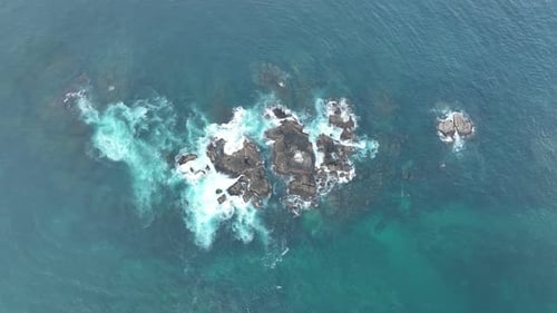 Waves Crash Against Rocks in the Ocean
