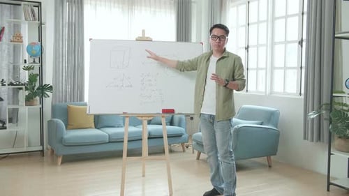 Young Adult Explains Math on Whiteboard at Home