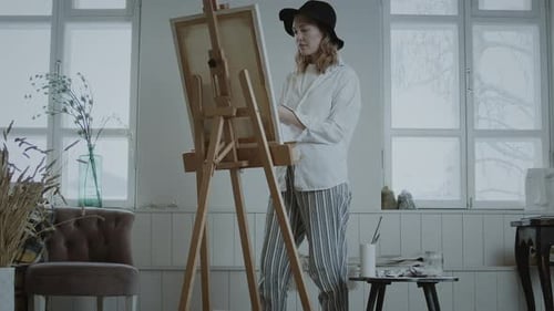 Young Woman Painting on Canvas in Bright Studio