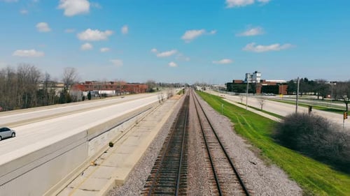 Unknown Train Starting Moving on Railway Track Through City Area with Sky on Background