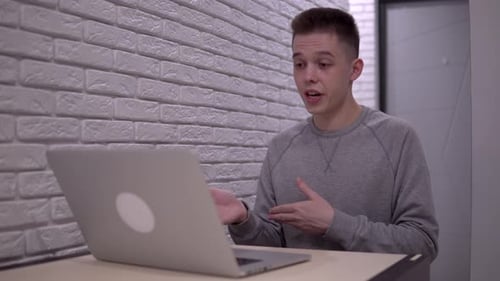 Young Man Having Cheerful Video Call on Laptop