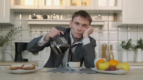 Exhausted Man Pours Coffee in Bright Kitchen