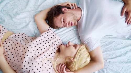 Junge Liebhaber liegen von Angesicht zu Angesicht im Bett