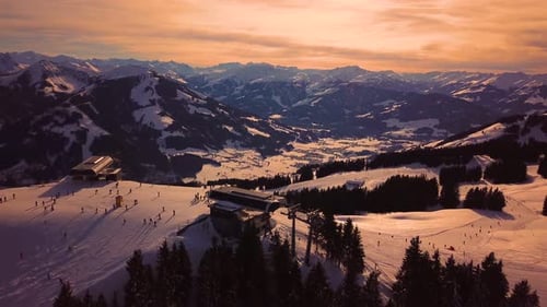 Snowy mountains in low clouds and blue sky at sunset in winter. Panoramic landscape with beautiful s