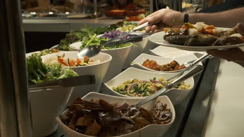 Buffet Table at the Restaurant. Hot and Fresh Food at a Mall Food Court. Self Service Meals. Woman