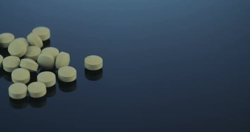 Pharmaceutical Tablets Piled on Reflective Blue Surface