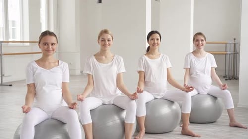 Entspannte schwangere Frauen führen einen aktiven, gesunden Lebensstil und gehen zum Yoga, Fitness und Sport