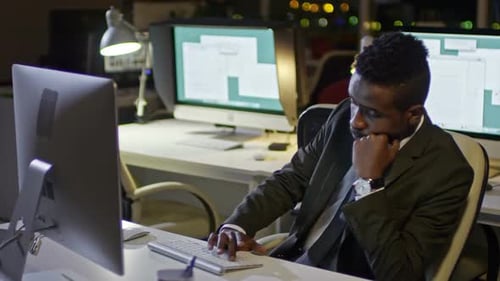 Young Office Worker Working on Computer at Night