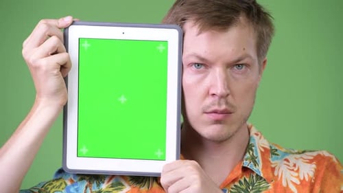 Man Holding Tablet with Green Screen Display
