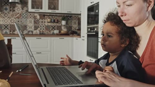 Mother and Child Using Laptop Together at Home