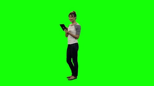 Woman Standing Using Tablet on Green Screen