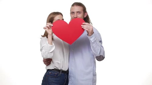 Smiling Couple Holding Red Heart and Kissing