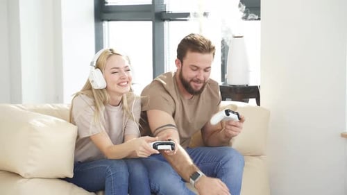 Couple Laughing and Playing Video Games at Home