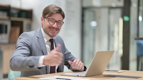 Thumbs Up By Positive Businessman Working in Office