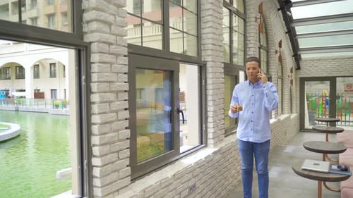 Young man talking by phone in cafe.
