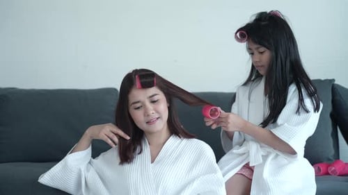 Girl Puts Rollers in Woman's Hair Indoors