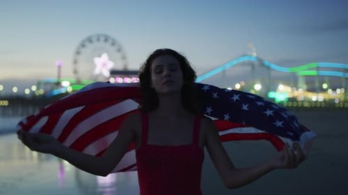 Evening view of a woman holding the US flag