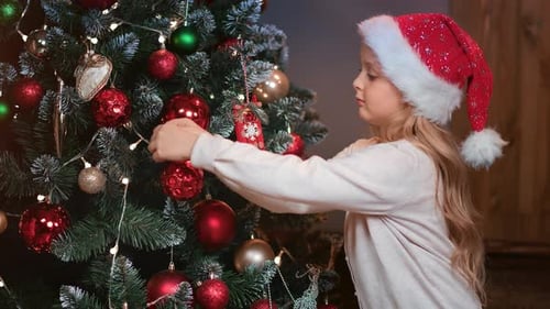 Child Decorating Christmas Tree in Cozy Home