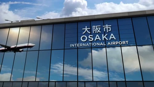 Airplane landing at Osaka Japan airport mirrored in terminal