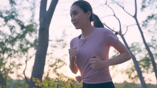 Asian young beautiful sport woman running on street in public park.