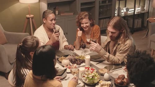 Friends Toasting with Wine at Cozy Dinner Party