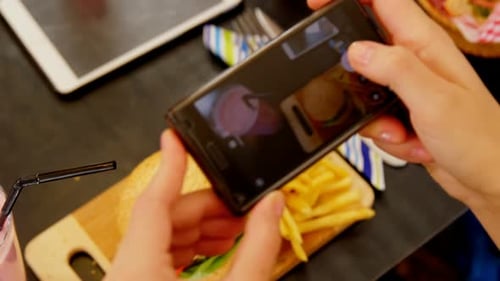 Person Taking Photo of Burger Meal with Smartphone