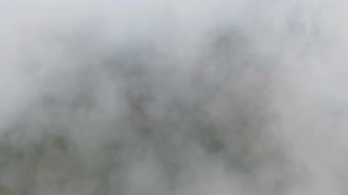Luftaufnahme des Sonnenaufgangs über flauschigem Seenebel, nebligen Wolken mit Berghügel
