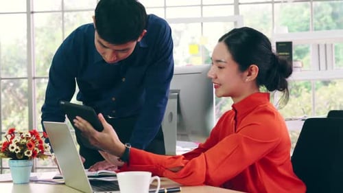 Two Business People Talk Project Strategy at Office