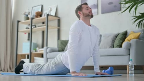 Man Exercises on Yoga Mat at Home