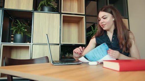 Woman Works on Laptop at Desk in Office