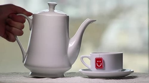 Pouring Water From Kettle Into Tea Cup