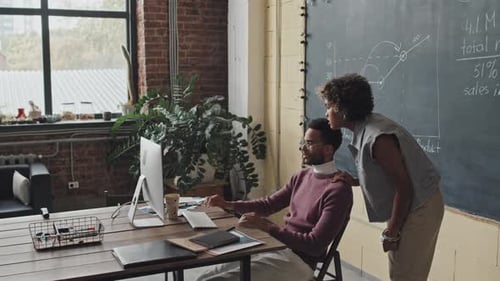Büroangestellte nutzen Computer gemeinsam
