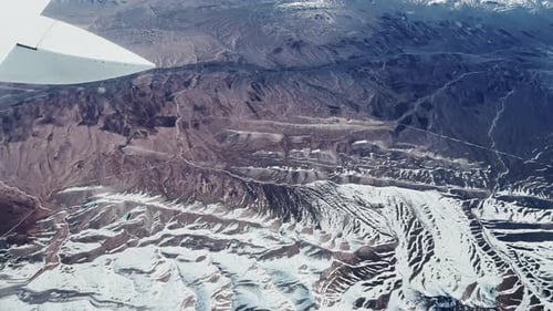 Aerial View of Snowy Mountain Landscape from Airplane