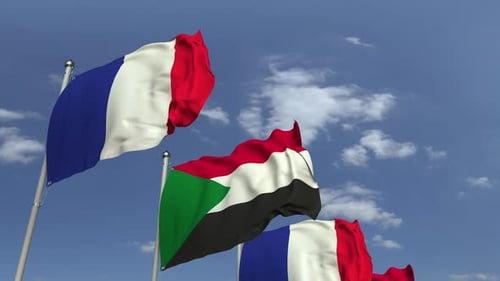 Waving National Flags of Sudan and France Against Blue Sky