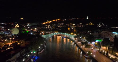 Night aerial view of Bridge of Peace and beautiful cityscape in the center of Tbilisi, Georgia 2022