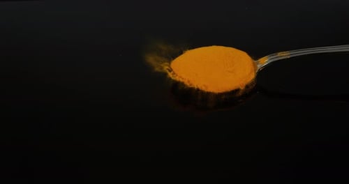 Turmeric, curcuma longa, Powder falling against Black Background, Indian Spice, Slow Motion 4K