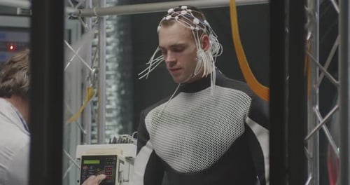 Man Wearing Wires Standing in Metal Structure