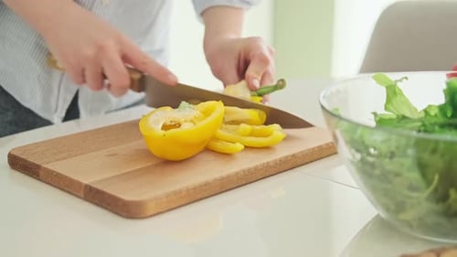 Frau in Küche bereitet Gemüsesalat zu